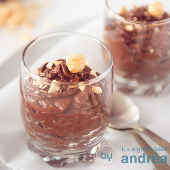 Twee glaasjes met chocolade mousse met hazelnoten topping