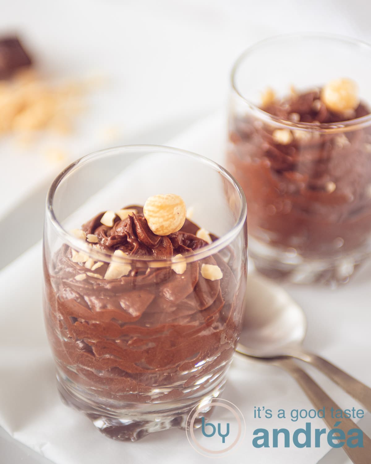 Twee glazen met chocolade mousse met hazelnoten