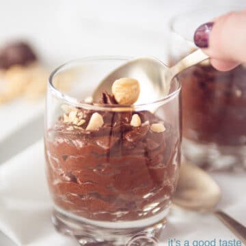 Een hand die een hapje chocolade mousse gaat pakken