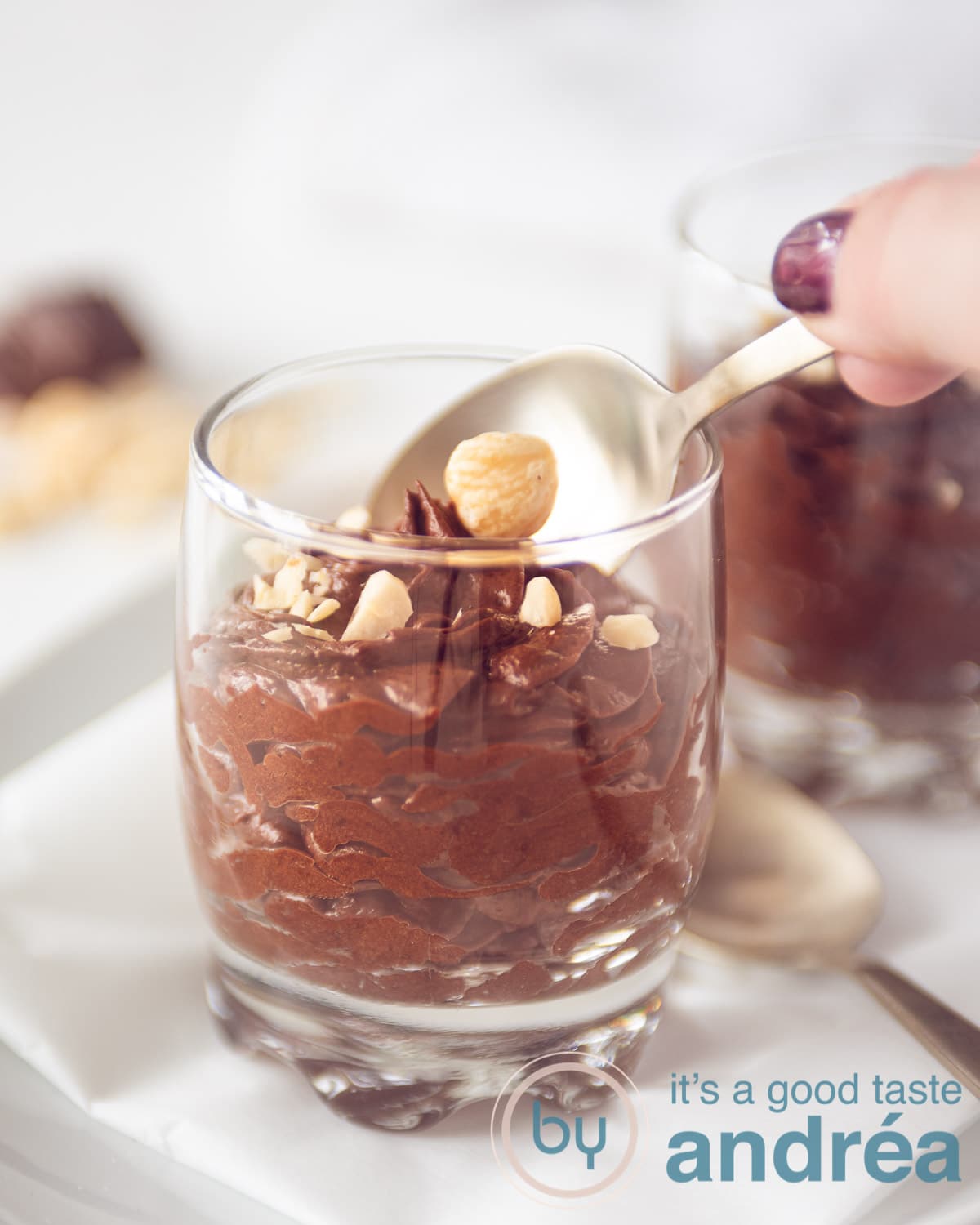 Een hand die een hapje chocolade mousse gaat pakken