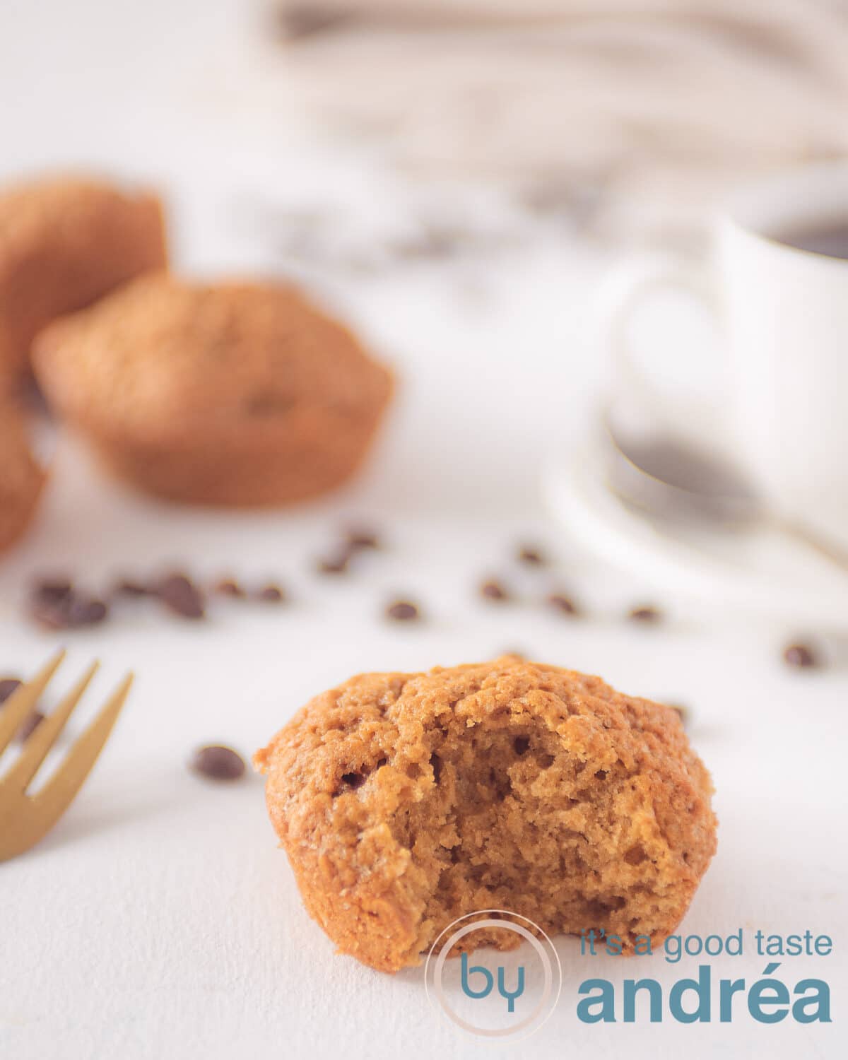 Een koffie muffin met een hap eruit. Wat muffins op de achtergrond