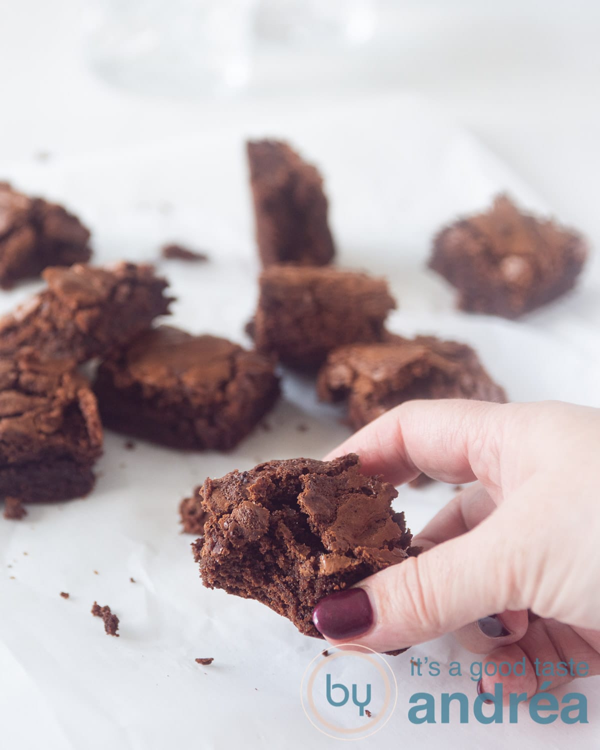 Een hand die en brownie pak. In de rest van het beeld liggen brownies