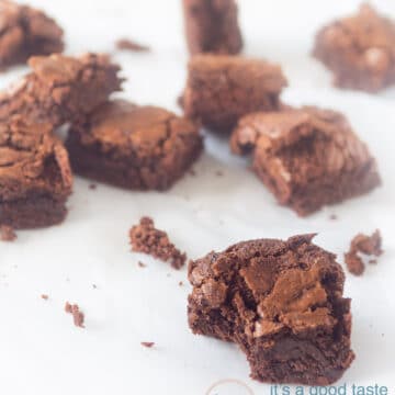 Smeuïge brownies met chocola verdeeld over een tafel. Bij de voorste is er een hapje uitgenomen