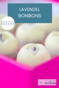 Een deel van een roze doos gevuld met witte chocola lavendel bonbons. Een tekst bovenin: makkelijk recept, lavendel bonbons