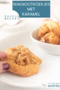 Een deel van een schaal met een walnootkoekje dat wordt vastgepakt. In de achtergrond een schaaltje met meer koekjes. Een tekst: walnootkoekjes met karamel, makkelijk recept