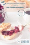 Een wit bord met een opengesneden scone met cranberry compote en clotted cream. Een text overlay beschrijft de foto.