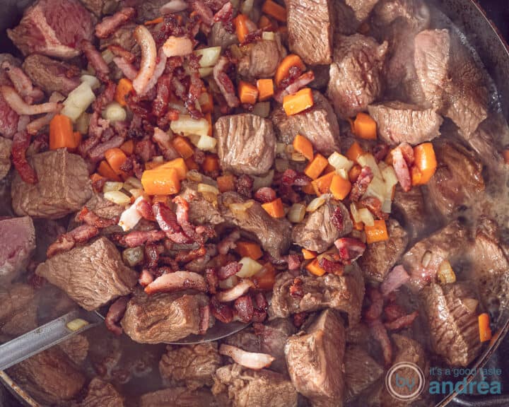 Een koekenpan met groenten, vlees en spekjes