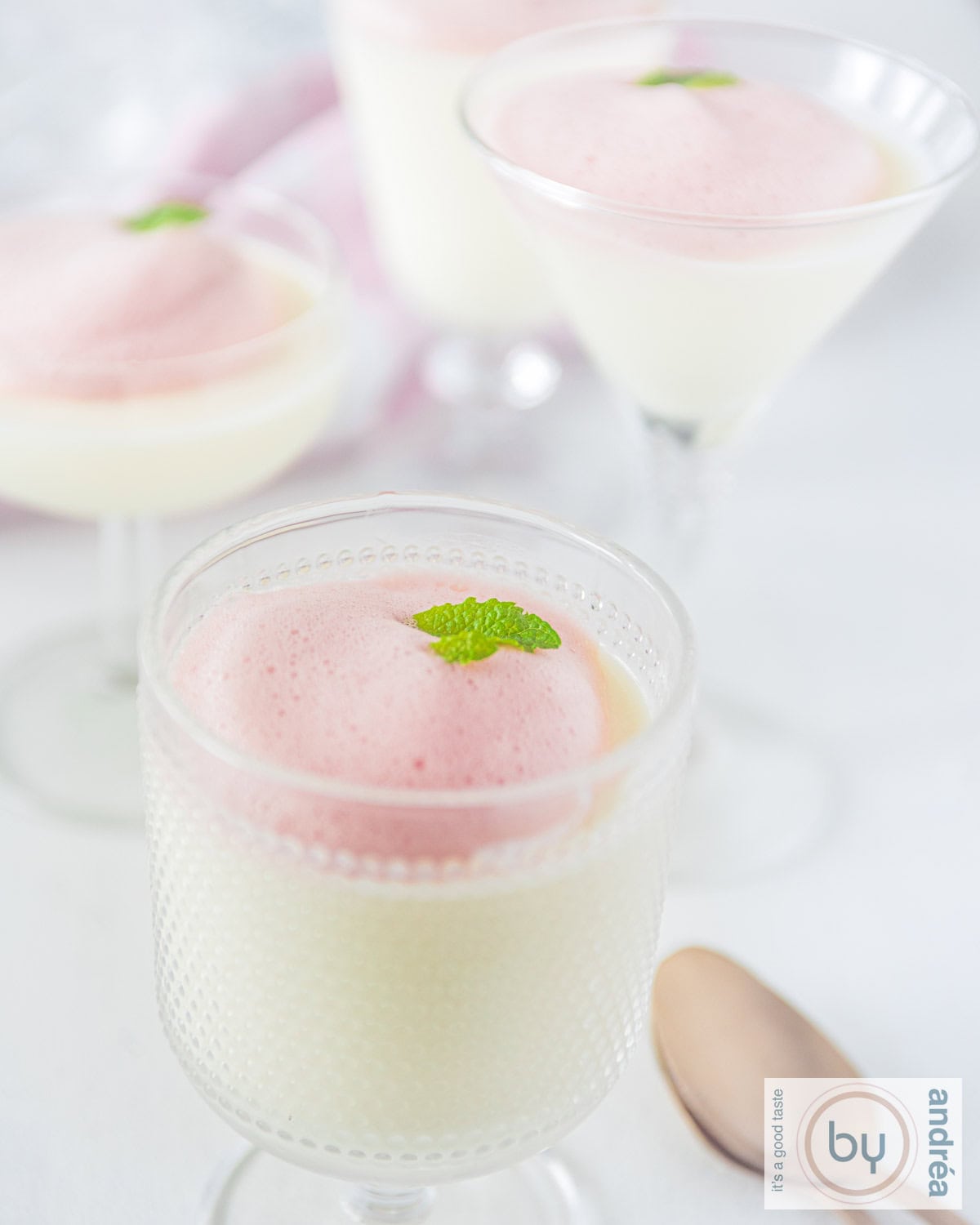 A couple of glasses of buttermilk panna cotta with berry foam in a glass.