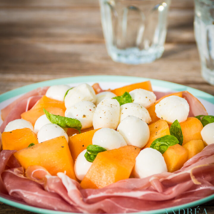 salade van meloen, ham en mozzarella op een bord