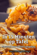 Vork met macaroni, gehakt en spekjes boven een donkere kom macaroni met geraspte kaas.