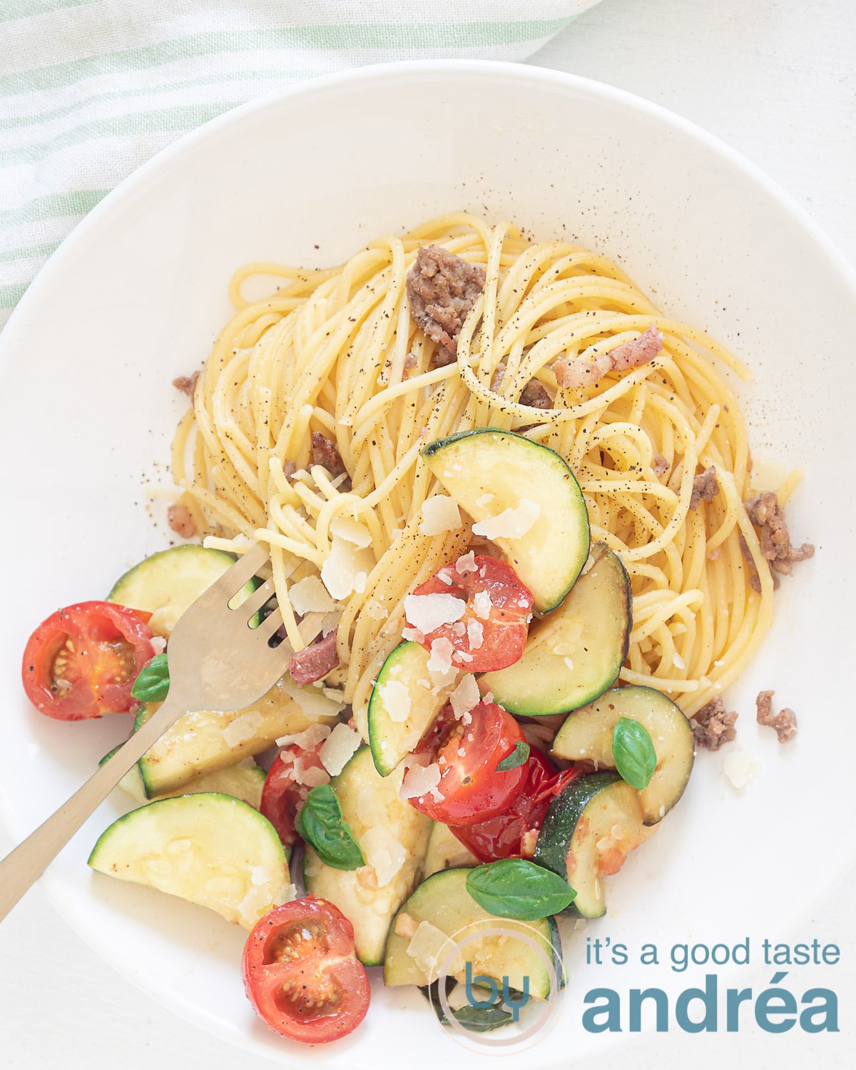 Spaghetti met roerbak courgette op bord van bovenaf.