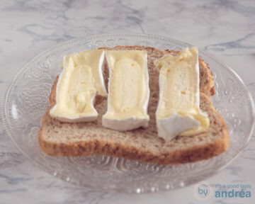 Een snee brood met plakken Camembert