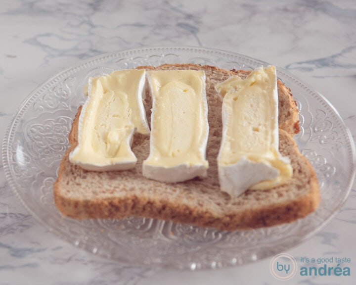 Een snee brood met plakken Camembert