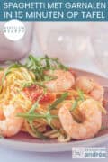 Een roze bord met spaghetti, rucola, tomaatjes en garnalen. Een tekst: makkelijk recept, spaghetti met garnalen in 15 minuten op tafel