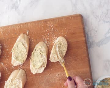 Plakjes stokbrood worden besmeert met kruidenboter.