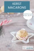 Een stervormig schaaltje met een macaron met zuurstokken voor de kerst. Een houten ondergrond. Een tekst bovenin: makkelijk recept, kerst macarons
