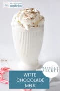 Een witte mok met slagroom gevuld met warme witte chocolademelk. Een tekst: makkelijk recept, witte chocolademelk
