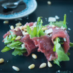 Rolletje carpaccio op een zwart bord