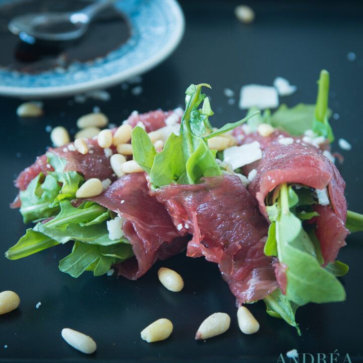 Rolletje carpaccio op een zwart bord