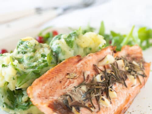 Rucolastamppot met gegrilde zalm op een bord