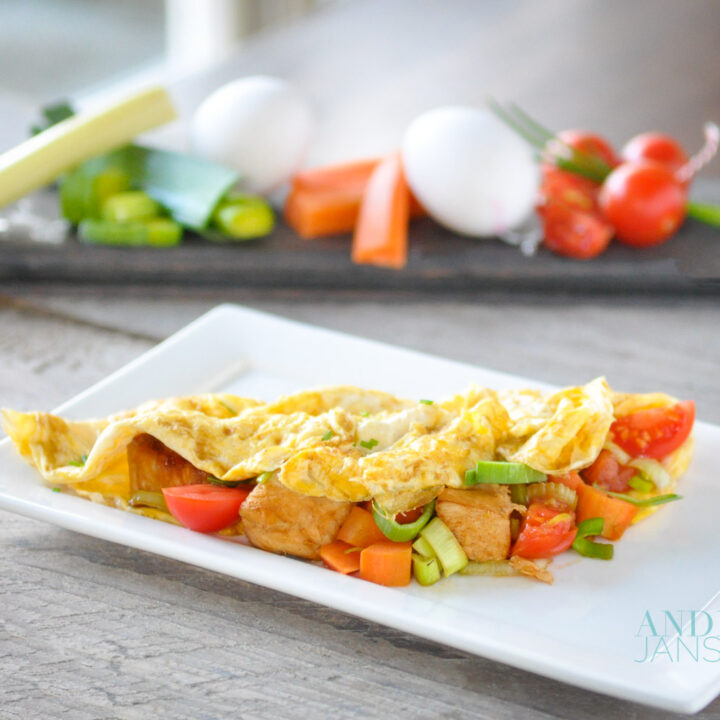 bord met gevulde omelet met kip en groenten