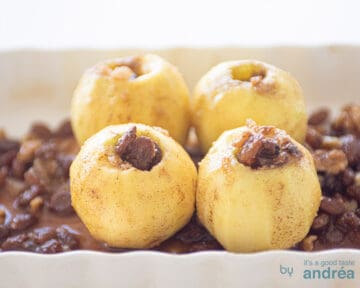 Gevulde appels op een bedje van rozijnen en water in een witte ovenschaal