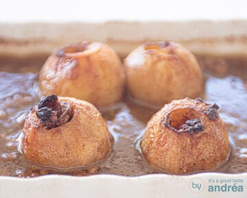 Gebakken appels in een karamelsaus in een witte ovenschaal