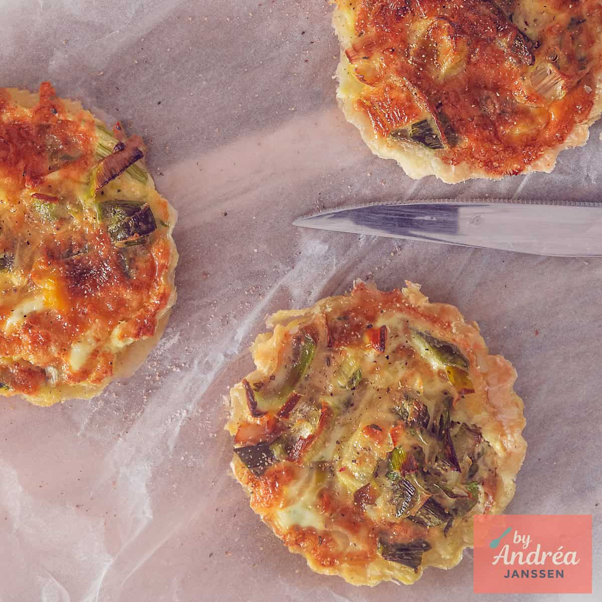 Een vierkante foto van bovenaf genomen met drie quiches met makreel, prei, kaas en tijm