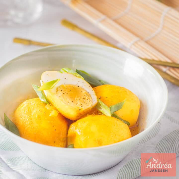 A green bowl with Indonesian style eggs in a coconut sauce