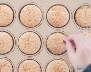 Een cupcake vorm met cupcakes waarin met een satéprikker gaatjes wordt geprikt