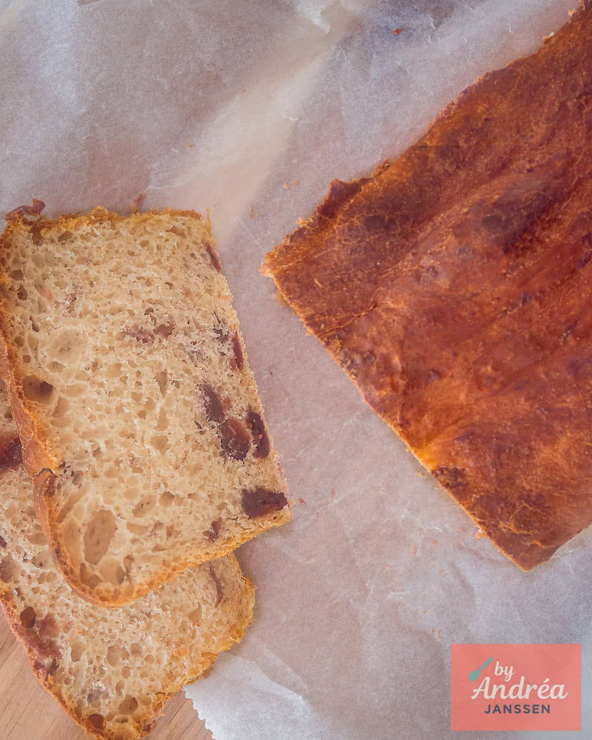 Foto van bovenaf van een cranberrybrood, met twee plakken op de voorgrond.
