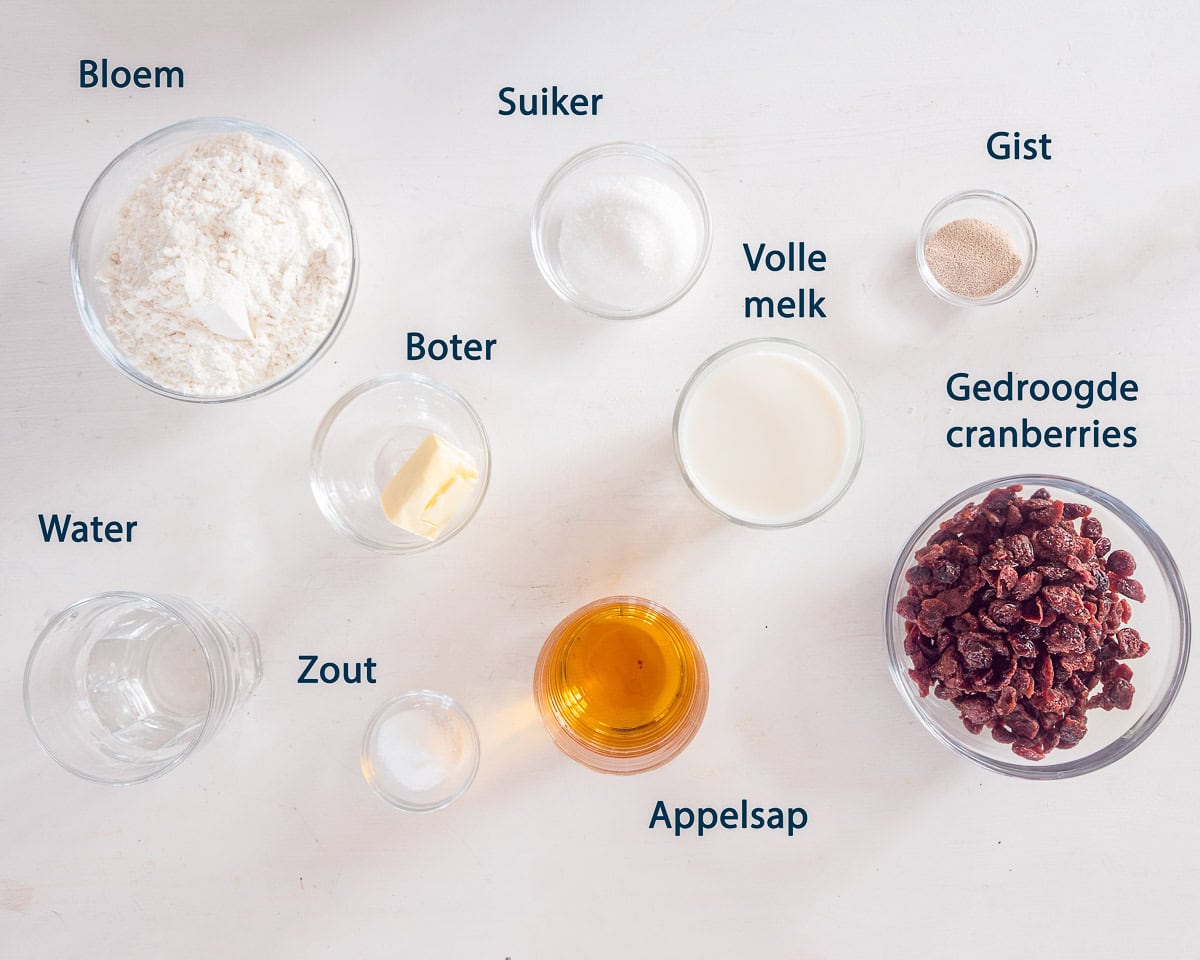 Ingredienten Cranberry brood op een witte ondergrond met tekst beschrijving.