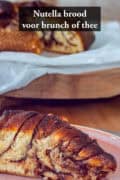 Een puntje van het Nutella brood in de voorgrond, de lagen goed zichtbaar. Een tekst bovenin: Nutella brood voor brunch of thee