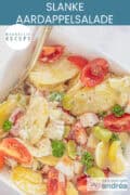 Een foto van bovenaf van een schaal met aardappelsalade, met groenten en een heerlijke dressing. Een tekst: makkelijk recept, slanke aardappelsalade