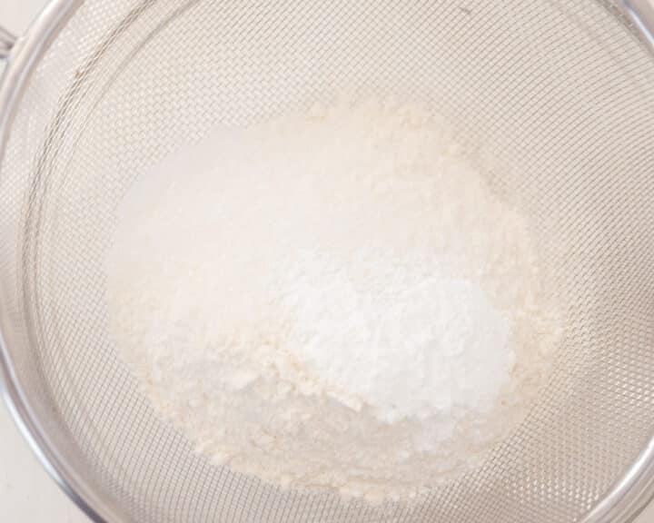 De ingrediënten worden gezeefd in een glazen kom.