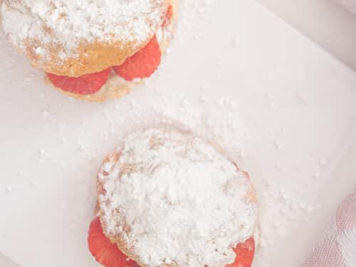 Een vierkante foto van twee scones van bovenaf gefotografeerd met een witte ondergrond.