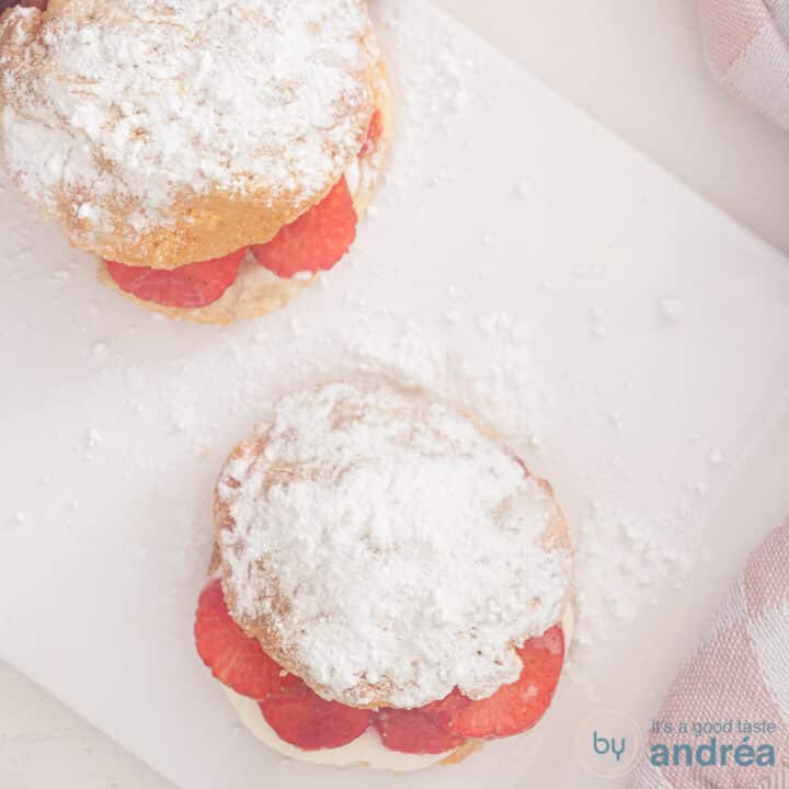 Een vierkante foto van twee scones van bovenaf gefotografeerd met een witte ondergrond.