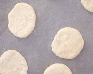 Een bakplaat gevuld met scones onafgebakken.