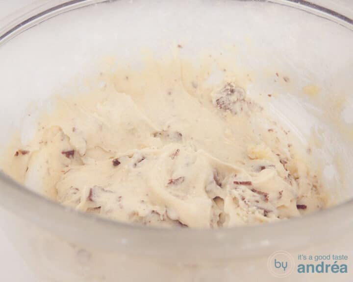 Een glazen kom met cupcake beslag met chocolate chips