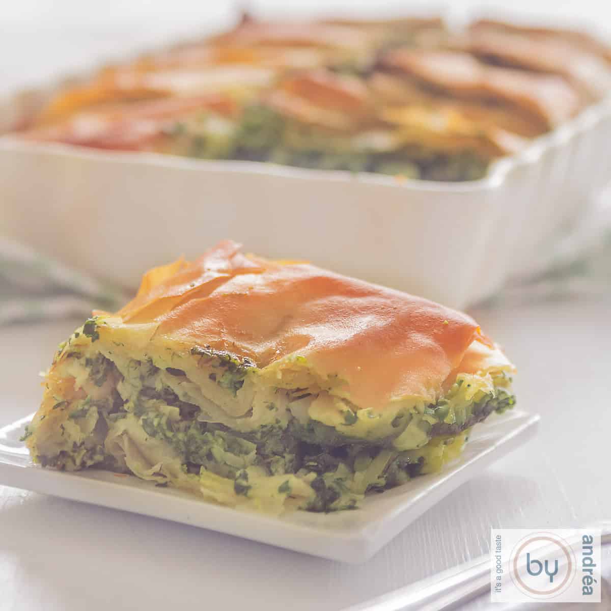 Een vierkante foto met een aantal stukken met hartige taart met spinazie en feta: spanakopita.