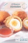 Twee hele Afrikaanse eibal snacks en 1 gehalveerde. Een schaaltje saus ervoor. Een tekstbeschrijving van eht recept bovenin