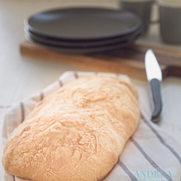 Zelfgebakken ciabatta op een keukendoek met mes en eetgerei