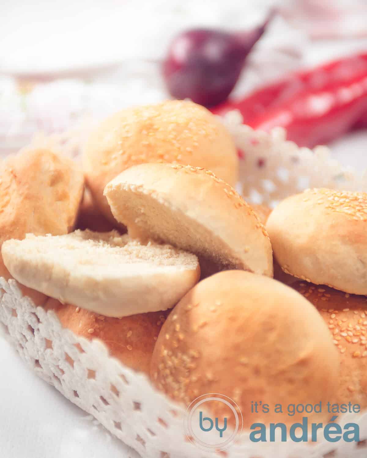 4 hamburgerbroodjes in een houten schaaltjes met tomaat en komkommer