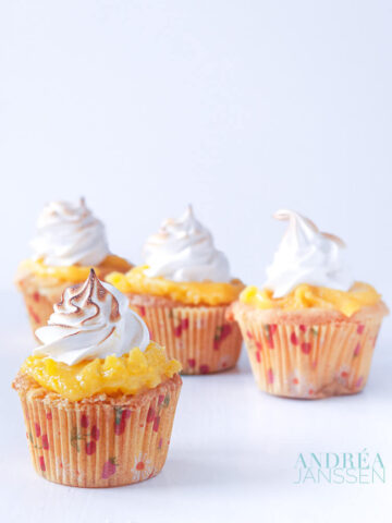 4 citroen meringue cupcakes op een witte plaat