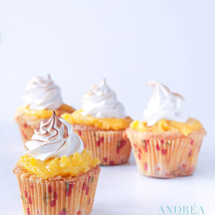 4 citroen meringue cupcakes op een witte plaat