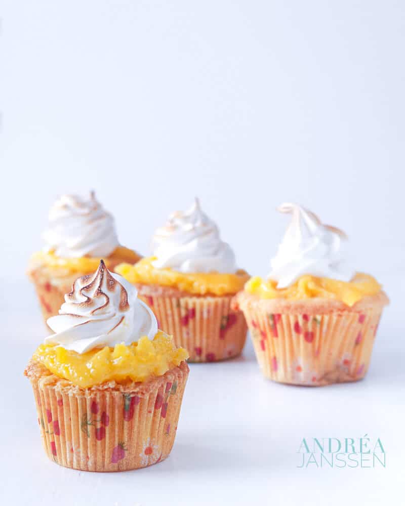 4 citroen meringue cupcakes op een witte plaat