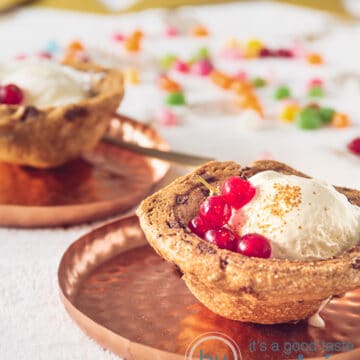 twee zandkoek bakjes gevuld met vanille ijs en rode bessen