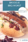 Een broodje met worst, uitjes en curry. Een tekst overlay: Broodje BBQ Worst makkelijk recept