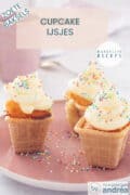 Drie ijsbekers gevuld met cupcake en een toef frosting met discodip op een roze bord. Bovenin een tekstoverlay: cupcake ijsjes, zoete baksels, makkelijk recept