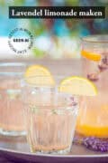 Twee glazen en een karaf gevuld met lavendel limonade met citroen. Een tekst bovenin lavendel limonade maken.
